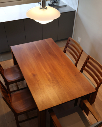 再塗装修理後のシャルドネのダイニングテーブルを上から見た様子。ブラックチェリー無垢材の天板が美しく補修され仕上がっている。