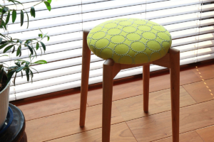 ミナペルホネンのタンバリン生地張りの、日進木工のトイスツール。オーク無垢材のフレームと丸い座面。