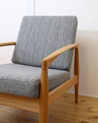 宮崎椅子製作所のペーパーナイフソファ1人掛け（オーク材）に、グレーのデンマーク製ストライプ生地の張地クッションを合わせている様子